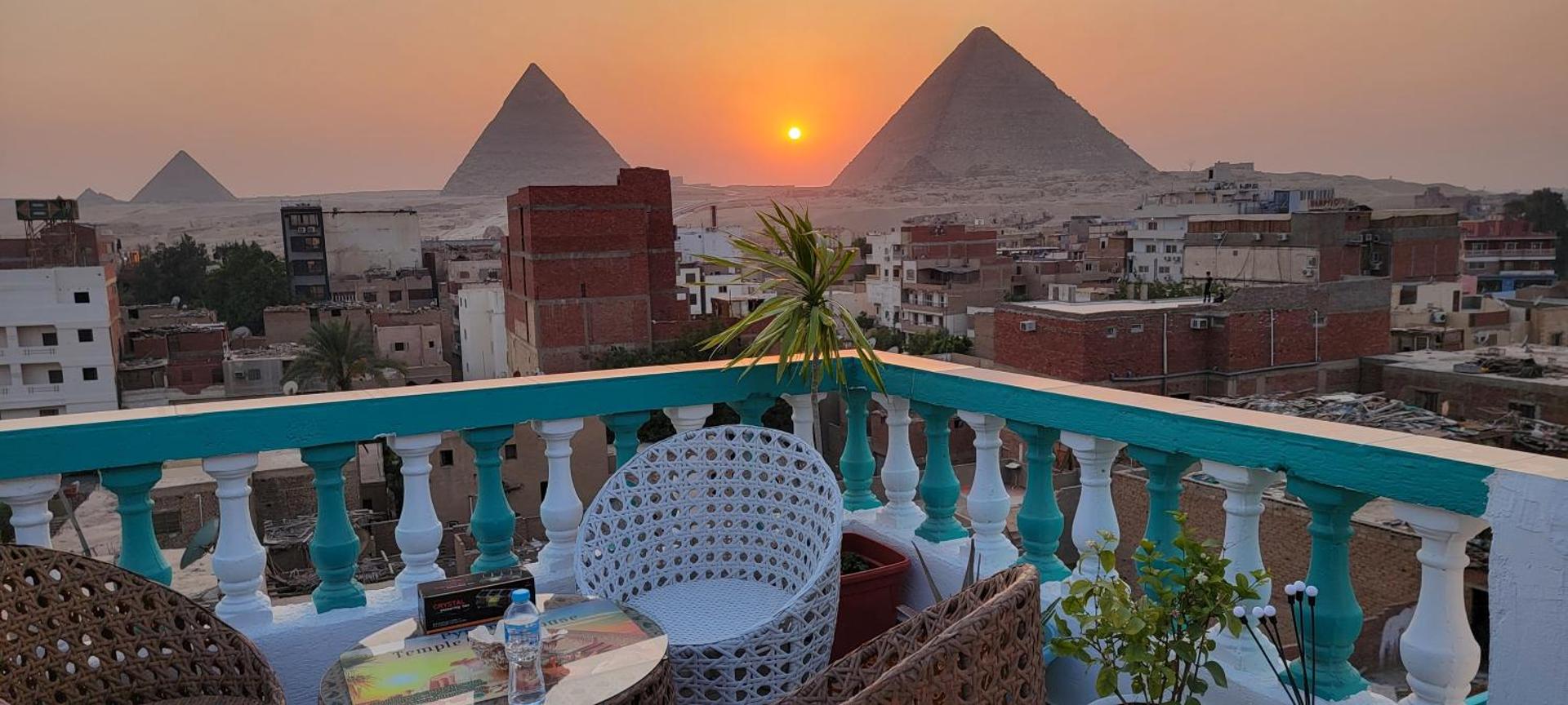 The sun setting between the pyramids of Giza, seen from the guest house rooftop